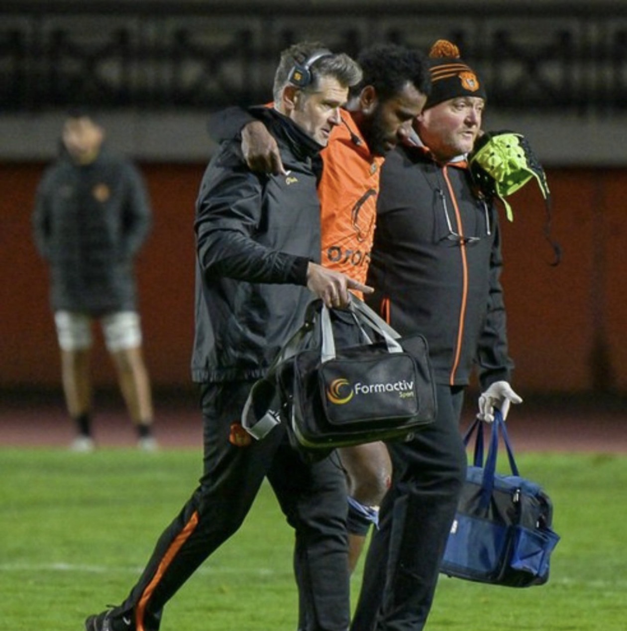 Nicolas Roger accompagnant un joueur blessé hors du terrain la nuit
